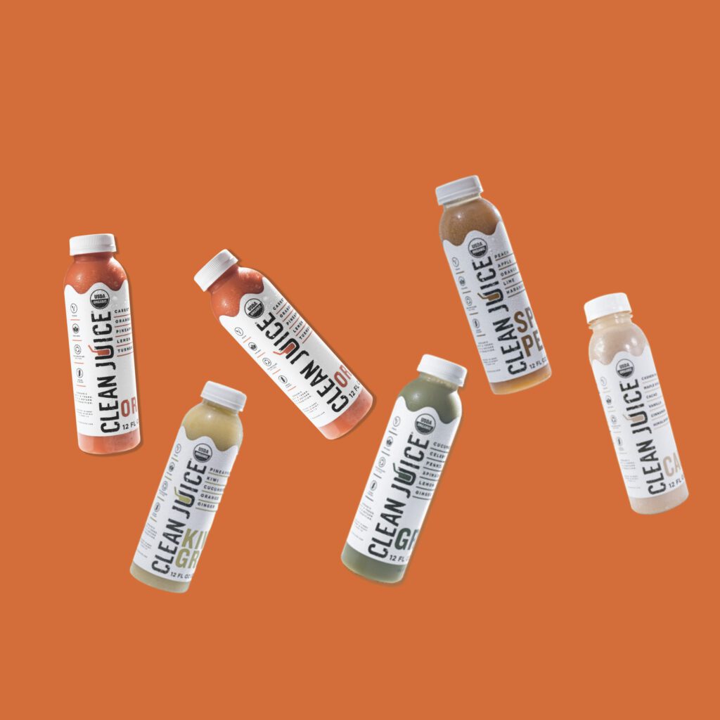 floating juice cleanse bottles on an orange background